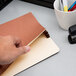 A hand holding a red Pendaflex letter size file pocket.