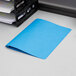 An Oxford light blue report cover on a white surface.