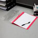 A red Oxford clear front report cover with a stack of papers inside.
