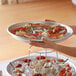 A person holding a Choice aluminum tray of clams and clams on ice.