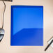 An Oxford PolyPort blue plastic folder on a wood surface with a mouse and keyboard.