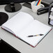 A Boorum & Pease log book open on a desk with a pen.