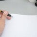 A hand holding a pen and writing in a Boorum & Pease log book.