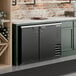 A black, counter-height, solid door back bar refrigerator with two doors and a vented section on the right side.
