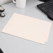 A white Pendaflex file folder with 2 fasteners and straight cut end tab on a desk.