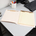 A Pendaflex letter size file folder with a legal pad inside on a desk.