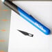 An X-Acto #11 knife blade on a piece of paper.