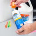 A person holding a bottle of Elmer's Clear Spray Adhesive.