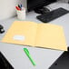 A yellow Oxford 2-pocket folder on a white desk.