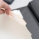 A person's hand holding an Oxford Manila file folder with a paper inside.