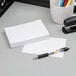 A pen on a piece of Oxford white ruled index card.