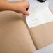 A hand holding a piece of paper with an Oxford Natural Earthwise Recycled Paper Pocket Folder.