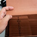 A hand holding a brown Pendaflex heavy duty expanding file folder.