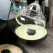 A glass with a green liquid being poured over Twang-a-Rita Unwind Lime Rimming Salt.
