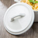 A white Bon Chef cocotte lid on a white surface.