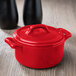 A red Bon Chef porcelain cocotte with a lid.