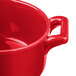 A close up of a Bon Chef red porcelain cocotte with handles.
