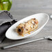 A white Bon Chef porcelain bowl with food on it.