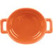 An orange porcelain oval cocotte with two handles.
