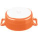An orange porcelain oval cocotte with white handles.