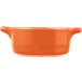 An orange porcelain oval cocotte with handles.
