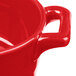 A close up of a red Bon Chef porcelain oval cocotte with a handle.