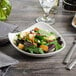 A salad in a white Bon Chef porcelain bowl.