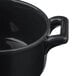 A close up of a matte black Bon Chef porcelain cocotte with handles.