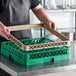 A man holding a green and beige plastic dish rack.