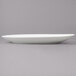 A Bon Chef white porcelain plate with a slanted long edge.