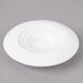 A white plate with a circular pattern and a hole in the middle.