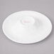 A white Bon Chef porcelain sampler plate with pink concentric circles.