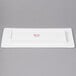 A white rectangular plate with a red logo.