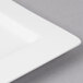 A close-up of a Bon Chef white rectangular bone china plate with a wide rim.