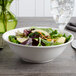 A white porcelain bowl filled with a vegetable salad.