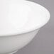 A close-up of a Bon Chef white porcelain bowl with a white rim.