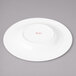 A white porcelain round salad plate with a pink concentric design.