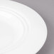 A close up of a Bon Chef white porcelain salad plate with a rim.