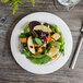 A close up of a salad on a white porcelain round plate.