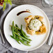 A Bon Chef white porcelain dinner plate with a pastry and green beans on it.