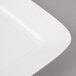 A close-up of a white square porcelain plate with a circle design.