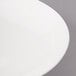 A close-up of a white Bon Chef porcelain dinner plate with a thin rim.