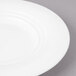 A close-up of a white Bon Chef porcelain bread and butter plate with a rim.