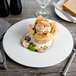 A Bon Chef white bone china plate with a piece of bread and a silver knife on it.