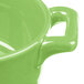 A close-up of a green Bon Chef porcelain oval cocotte with handles.
