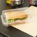 A sandwich in a Durable Packaging clear plastic hinged lid container.