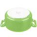 A green porcelain cocotte with a white lid.