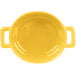 A yellow porcelain oval cocotte with handles.