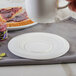 A white Bon Chef porcelain saucer with a cup and jam on it.
