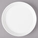 A white Bon Chef porcelain plate with a white rim on a gray surface.